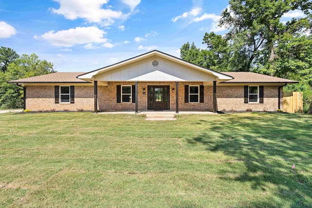 single story home featuring a front lawn, fence, and brick siding