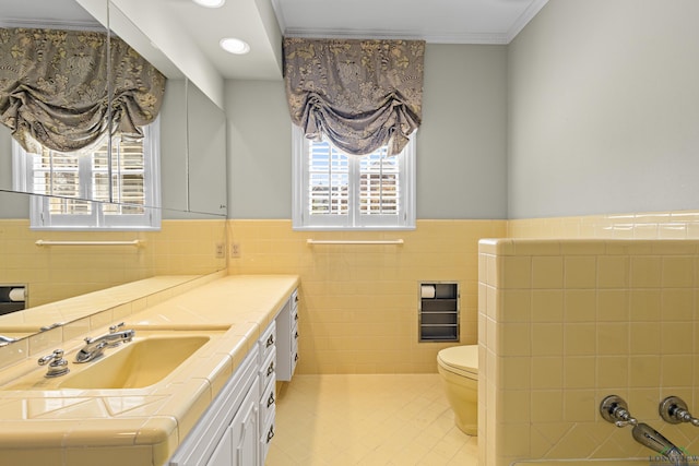 bathroom featuring tile walls, vanity, ornamental molding, and toilet