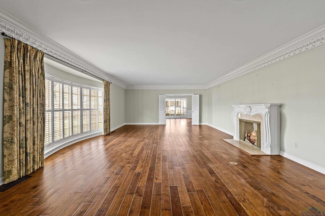 unfurnished living room featuring dark wood-type flooring, ornamental molding, and a premium fireplace