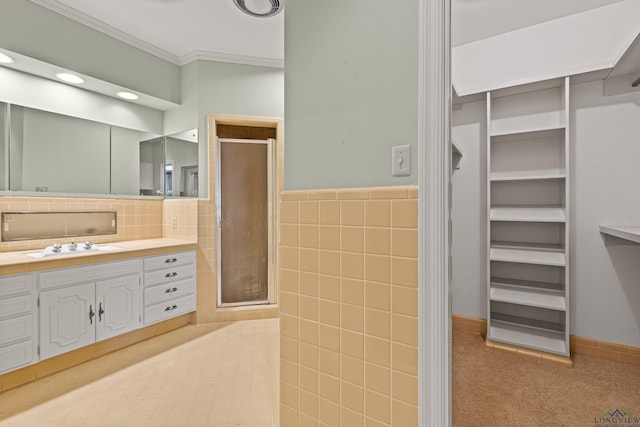 bathroom with crown molding, vanity, walk in shower, and tile walls