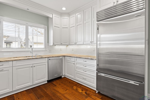 kitchen with sink, white cabinetry, tasteful backsplash, appliances with stainless steel finishes, and dark hardwood / wood-style flooring