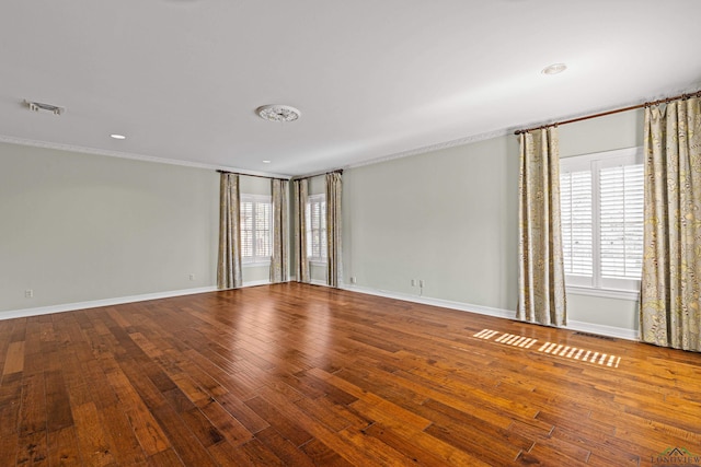 empty room featuring wood-type flooring and crown molding