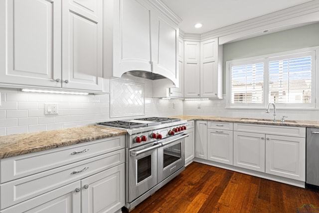 kitchen featuring dark wood-type flooring, sink, white cabinets, stainless steel appliances, and backsplash