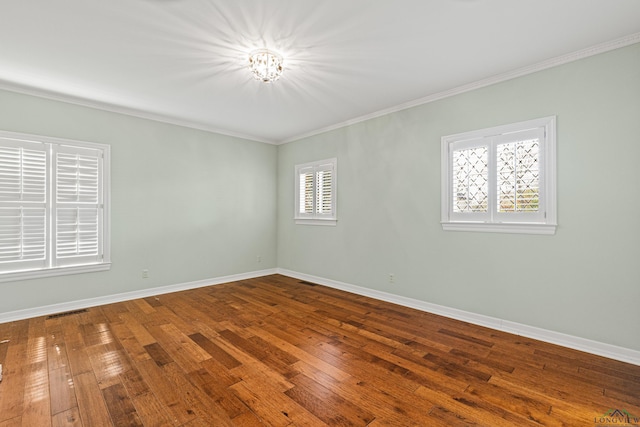 spare room featuring hardwood / wood-style flooring, ornamental molding, and plenty of natural light