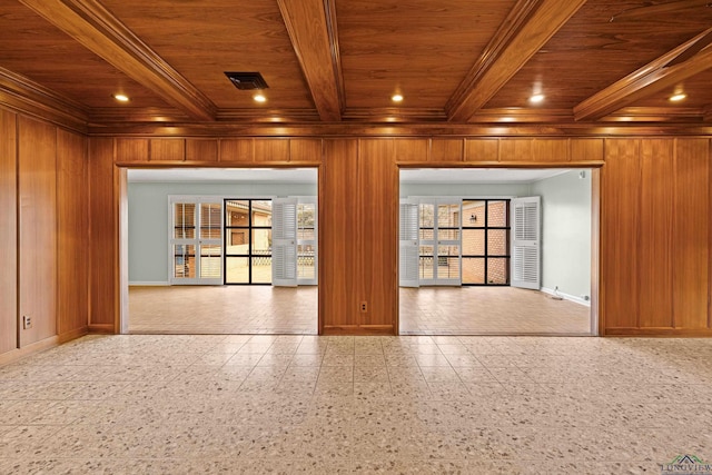 spare room featuring wooden walls, wooden ceiling, and beamed ceiling