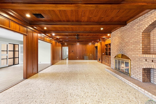 interior space featuring wood ceiling, a fireplace, wooden walls, and beam ceiling