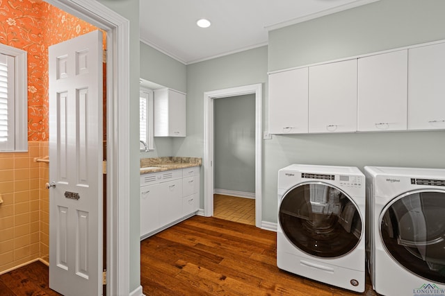 washroom with cabinets, crown molding, dark wood-type flooring, and washer and clothes dryer