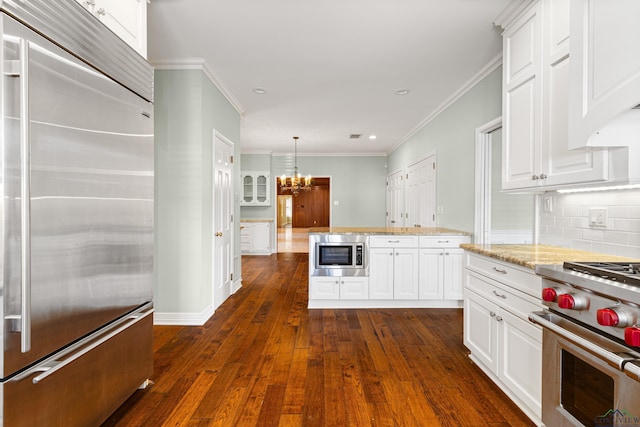 kitchen with dark hardwood / wood-style floors, decorative light fixtures, white cabinets, a chandelier, and built in appliances