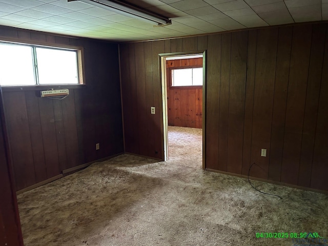 carpeted empty room with wooden walls