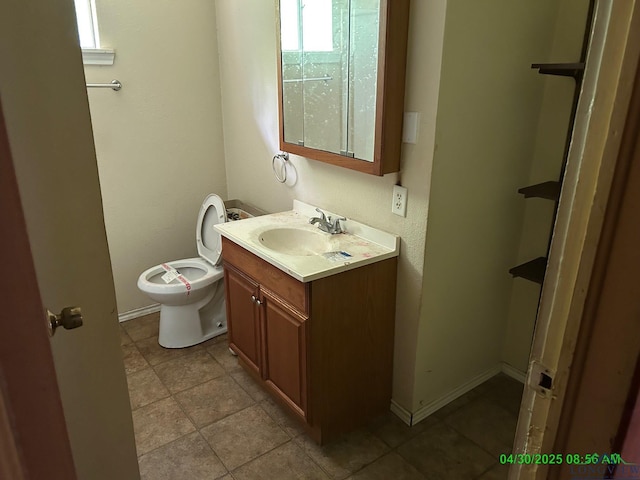 half bathroom with vanity, baseboards, and toilet