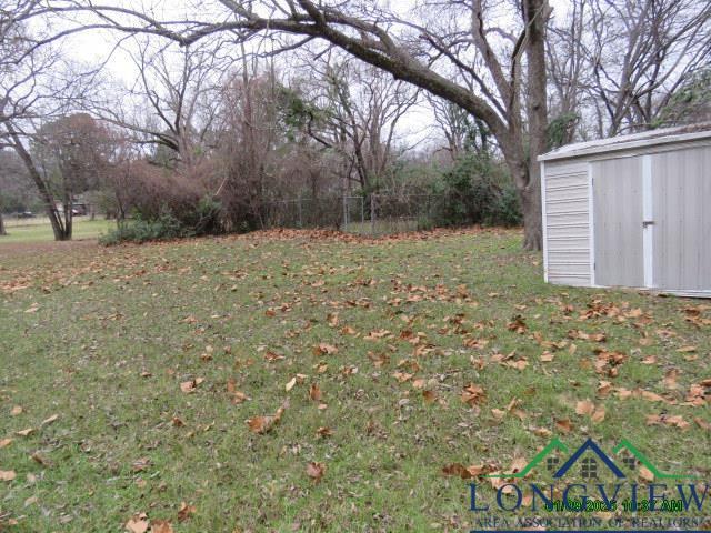 view of yard featuring fence, an outdoor structure, and a storage unit