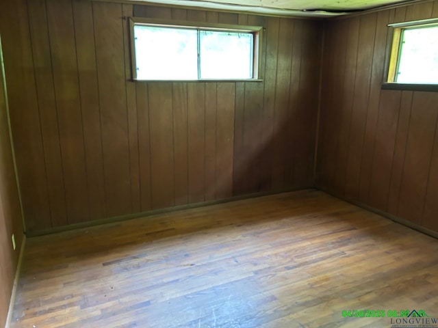 spare room with wood-type flooring and wood walls
