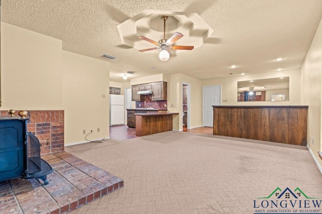 living room with a textured ceiling, dark carpet, and ceiling fan