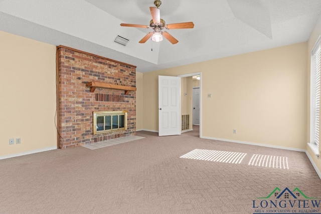 unfurnished living room with carpet flooring, a brick fireplace, and ceiling fan