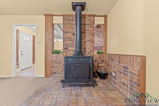 interior details with a wood stove, carpet floors, and a textured ceiling