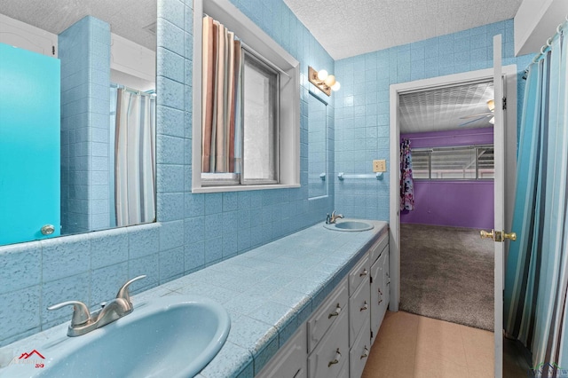 1320 Pinehill Dr, Jefferson, TX 75657 - bathroom with a textured ceiling, tile walls, and double vanity