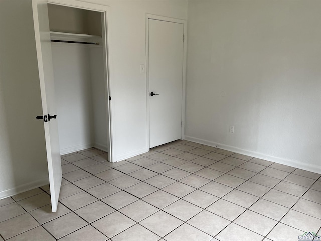 unfurnished bedroom with a closet and light tile patterned floors