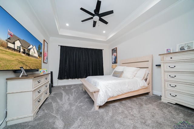 carpeted bedroom with a tray ceiling, ceiling fan, and ornamental molding