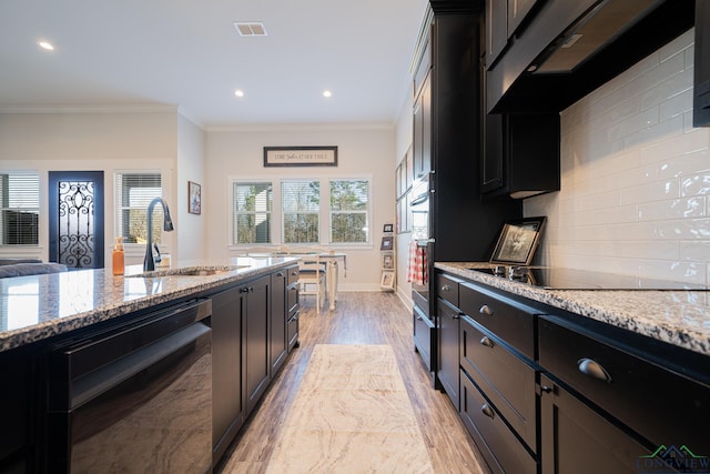 kitchen featuring light stone counters, sink, black appliances, and ornamental molding