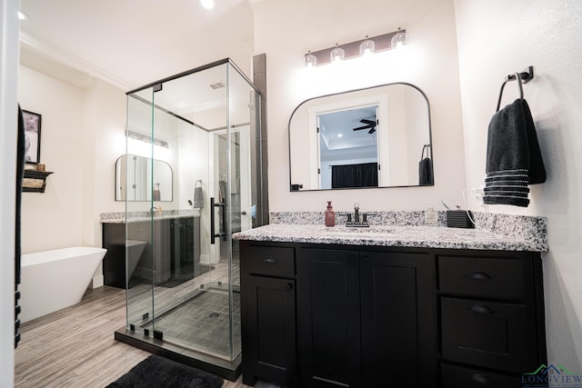 bathroom with vanity, ceiling fan, separate shower and tub, ornamental molding, and wood-type flooring