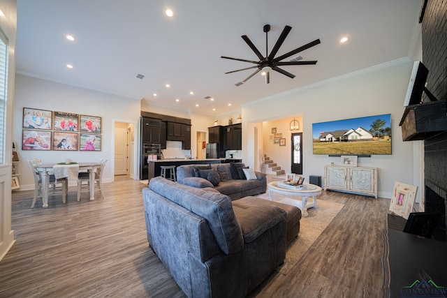 living room featuring ceiling fan, crown molding, and light wood-type flooring