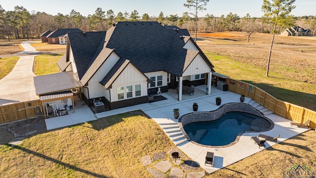 exterior space with a fenced in pool, a patio area, a lawn, and cooling unit