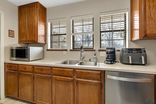 kitchen featuring plenty of natural light, stainless steel appliances, a sink, and light countertops