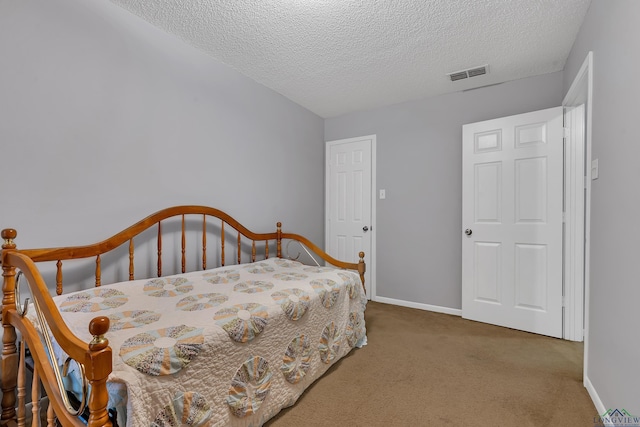 carpeted bedroom with visible vents, a textured ceiling, and baseboards