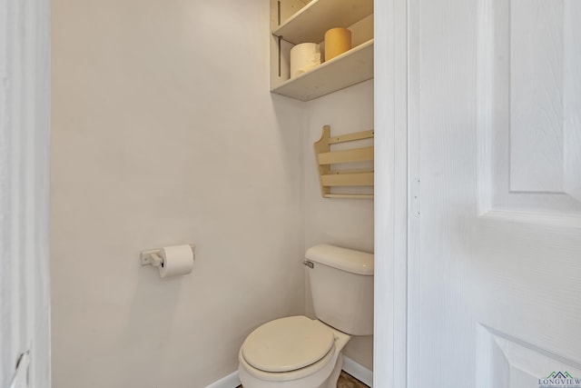 bathroom with baseboards and toilet