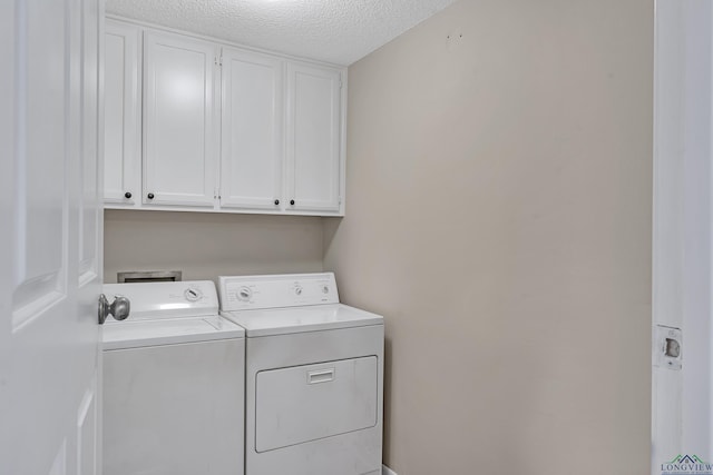 laundry room featuring cabinet space, washing machine and dryer, and a textured ceiling