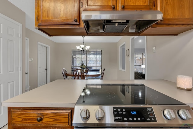 kitchen with stainless steel range with electric stovetop, light countertops, brown cabinets, and extractor fan