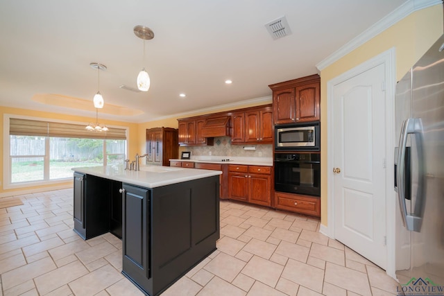 kitchen with decorative backsplash, sink, black appliances, decorative light fixtures, and a center island with sink