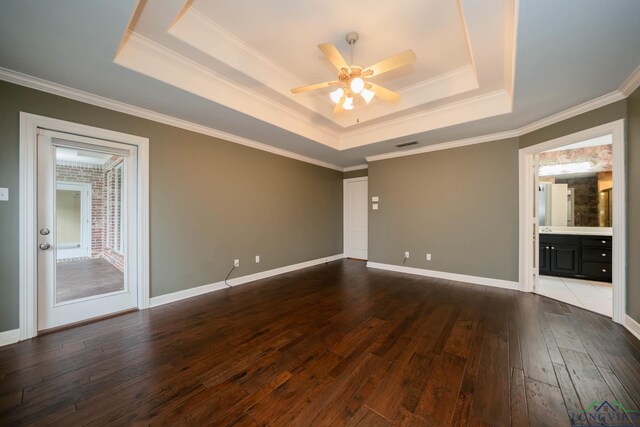 spare room with dark wood-type flooring, a raised ceiling, ceiling fan, and crown molding