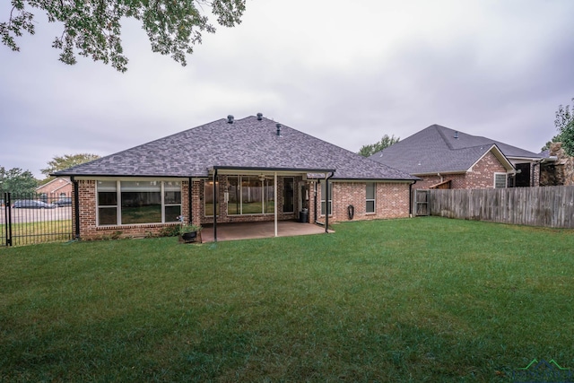 back of property with a patio area and a yard