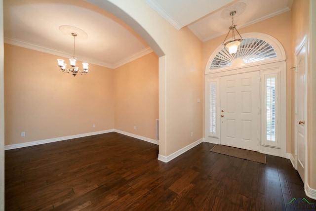 foyer entrance with crown molding, dark wood-type flooring, and an inviting chandelier