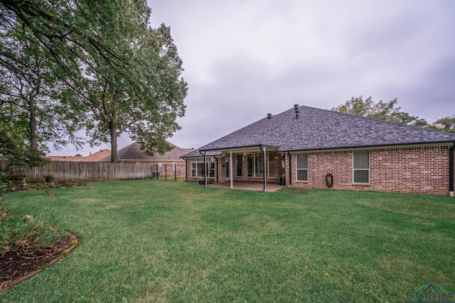 rear view of property featuring a lawn and a patio