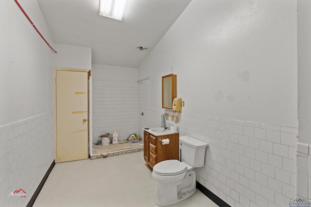 bathroom featuring vanity, toilet, and tile walls