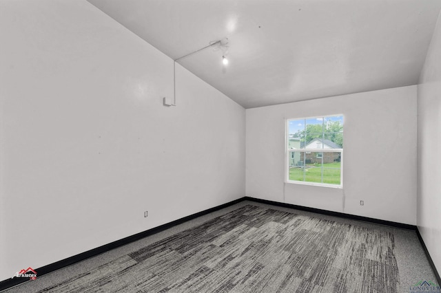 spare room featuring dark colored carpet