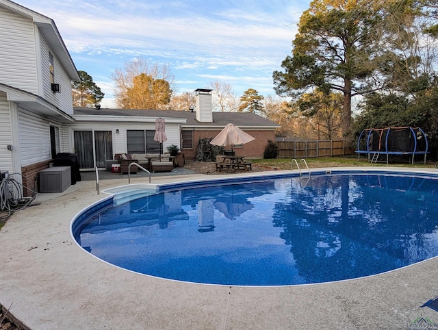 view of pool featuring a patio, a trampoline, fence, outdoor lounge area, and a fenced in pool