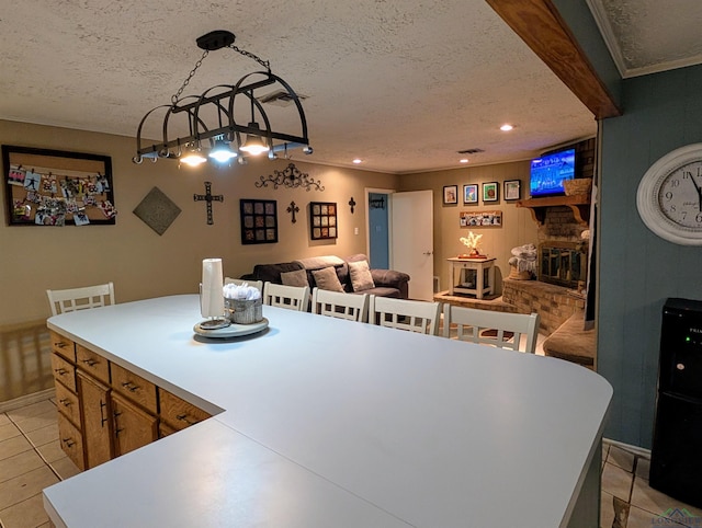 dining space featuring ornamental molding, light tile patterned floors, recessed lighting, a fireplace, and a textured ceiling