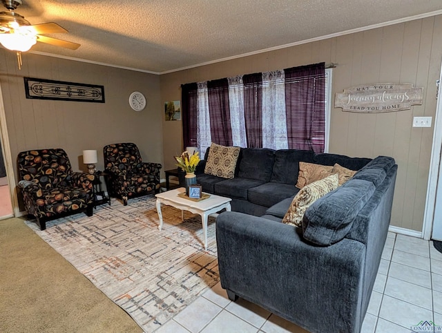 living room featuring a textured ceiling, light tile patterned flooring, a ceiling fan, and ornamental molding