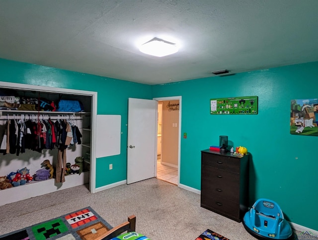 carpeted bedroom featuring baseboards, visible vents, and a closet