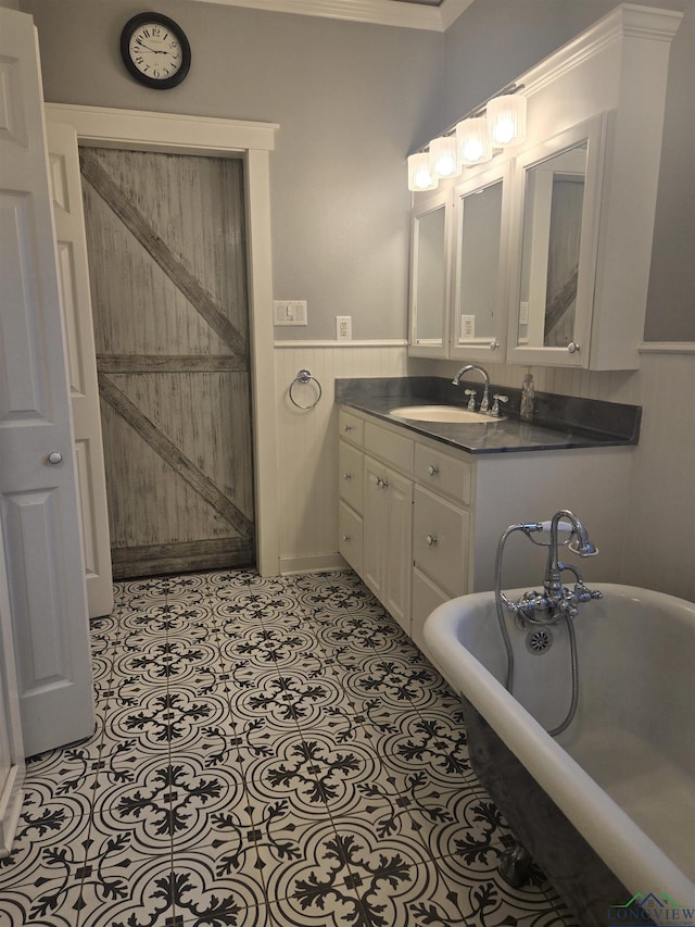 bathroom with a tub to relax in, tile patterned floors, vanity, and ornamental molding