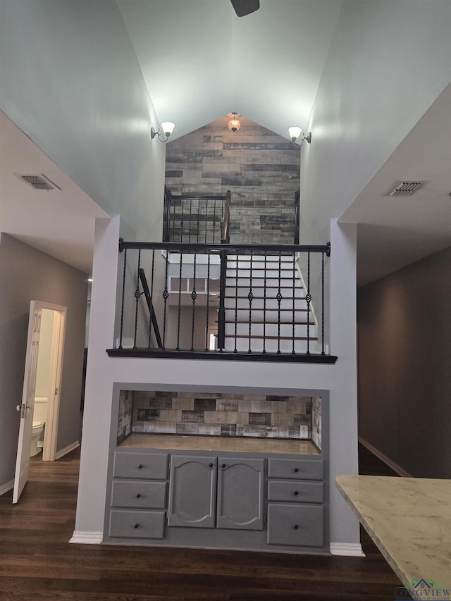 stairs featuring high vaulted ceiling and hardwood / wood-style floors