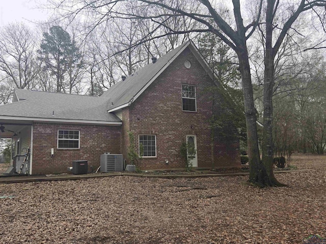 rear view of property with central AC