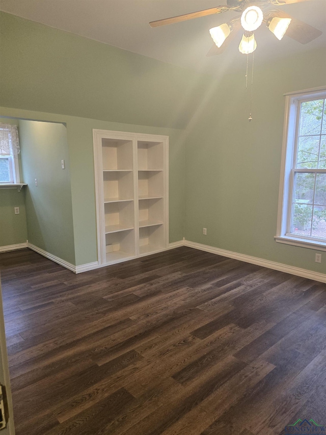 additional living space with dark wood-type flooring, ceiling fan, and built in features