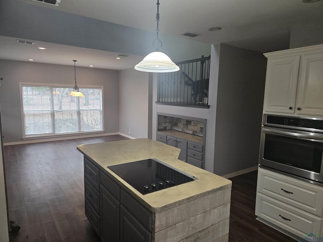 kitchen featuring white cabinetry, decorative light fixtures, a kitchen island, black electric stovetop, and oven