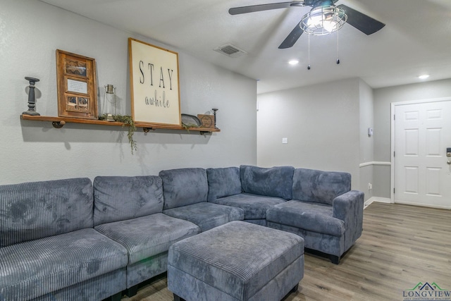 living area with recessed lighting, visible vents, baseboards, and wood finished floors