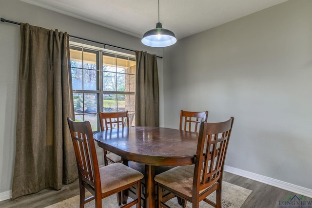 dining space featuring baseboards and wood finished floors