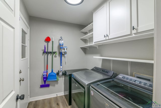 washroom with cabinet space, baseboards, washer and dryer, and wood finished floors